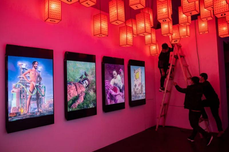 Des employés préparent l’une des premières expositions physiques de crypto art à Pékin, le 26/03/21 © Crédits : NICOLAS ASFOURI - AFP